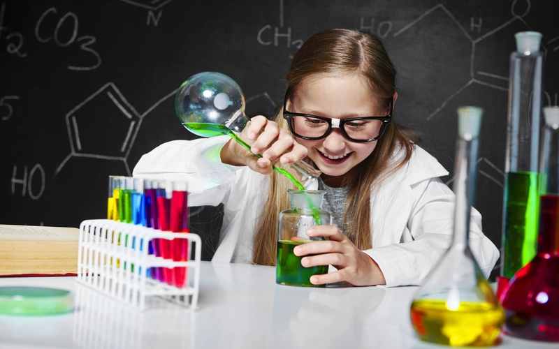 Dziewczynka w stroju chemika z menzurkami